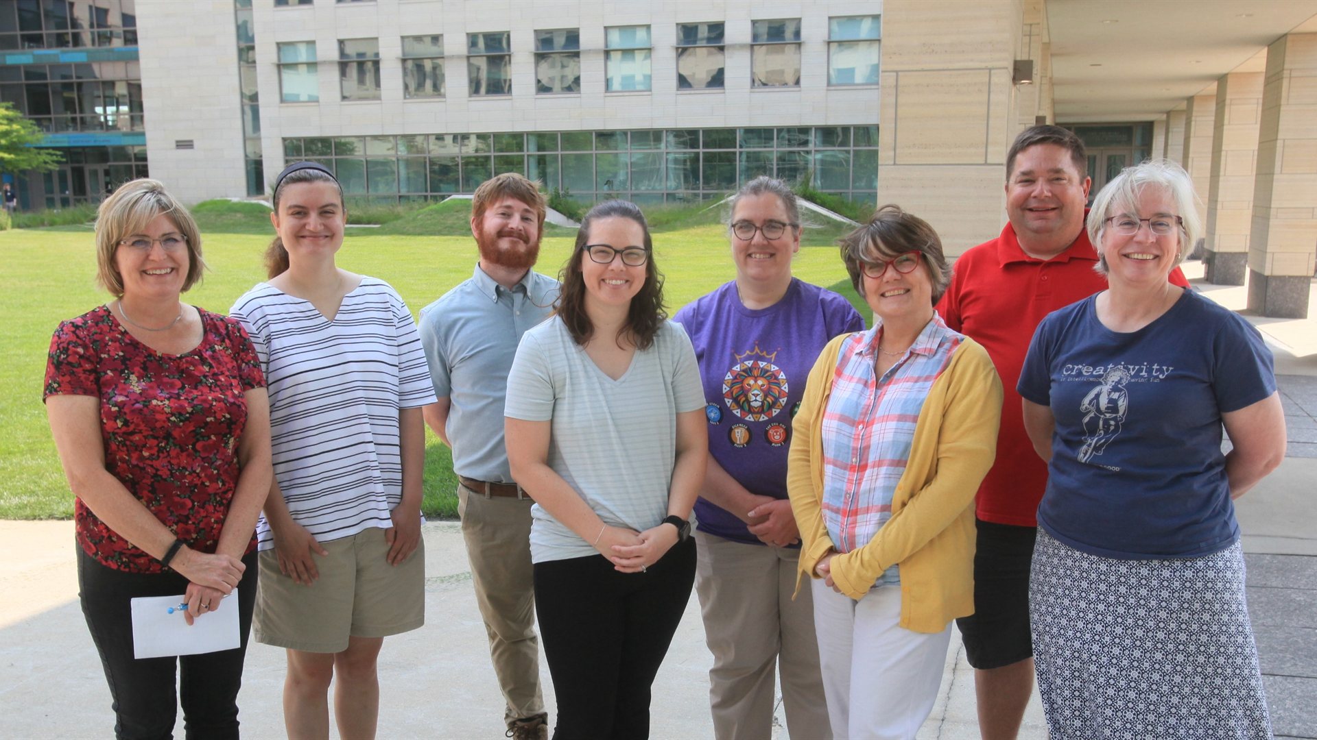 A group of Jumpstarting Student Research Fellowship educators standing together outside on the University of Iowa campus